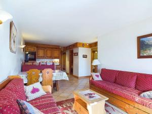 a living room with red couches and a kitchen at Appartement 3 pièces Sud avec balcon, parking et proche pistes et commerces - FR-1-398-571 in La Rosière
