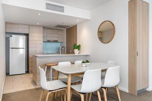 黄金海岸Modern 2BR Broadbeach Ocean Hinterland Views的厨房兼餐厅，配有桌椅