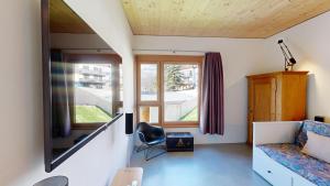 ein kleines Zimmer mit einem Sofa und einem Fenster in der Unterkunft Apartment Sella Nouva in Pontresina