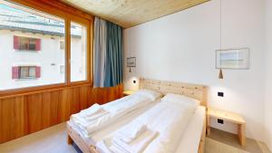 ein Schlafzimmer mit einem Bett und einem Fenster in der Unterkunft Apartment Roseg Nouva in Pontresina