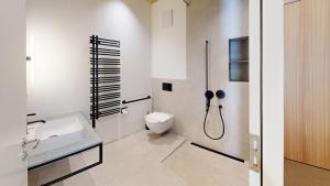 ein weißes Badezimmer mit Dusche und Toilette in der Unterkunft Apartment Roseg Nouva in Pontresina + 11 Fotos