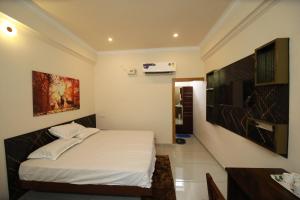 una camera da letto con un letto e una televisione di Star Light Residency a Munroe Island