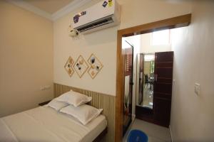 una piccola camera da letto con un letto e uno specchio di Star Light Residency a Munroe Island