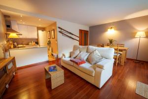 a living room with a couch and a kitchen at Apartament Vega - Vall Fosca - L'Amfitriona in Espúy