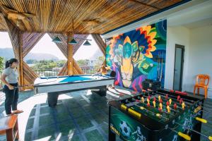 峰牙Green Riverside Cosy Home的一位女士站在一幅绘有台球桌的壁画前。