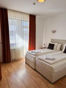 una camera da letto con due letti e una grande finestra di Sunny two bedroom apartment 12 in Tulip , Flora Residence - prime location! a Borovets Altre 47 foto