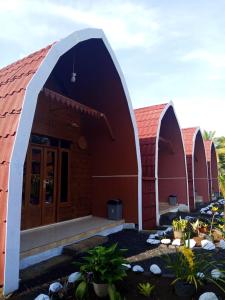 two red buildings with an arched entry way at Indah Damai Cottages in Sidomukti