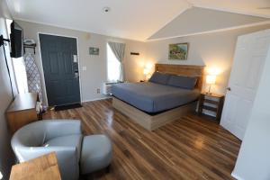 a bedroom with a bed and a couch and a chair at Lakeside Resort in Watkins Glen