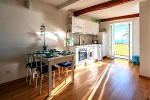 a kitchen with a table and chairs and a kitchen with the ocean at Your Sea Escape in Riva Trigoso