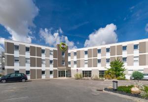 a hotel with a car parked in a parking lot at B&B HOTEL Romilly-sur-Seine in Romilly-sur-Seine