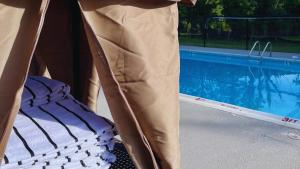 a person is standing next to a mattress next to a swimming pool at Cove Creek Lodge 208 Accessible Double Queen Room ADA in Oakland