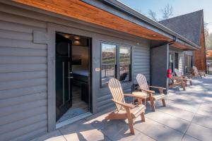 a patio with two chairs and a building with windows at Cove Creek Lodge 208 Accessible Double Queen Room ADA in Oakland