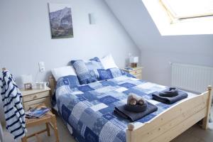 a bedroom with a blue and white bed with towels on it at Gîtes Estives d'Arrens in Arrens-Marsous
