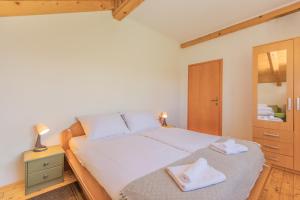 a bedroom with a large white bed with towels on it at Villa Hills in Janja Gora +32 photos