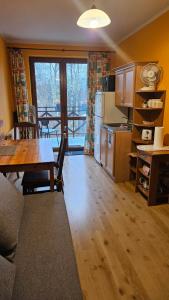 Una sala de estar con una mesa y una cocina. en Noclegi u Ireny, en Duszniki-Zdrój
