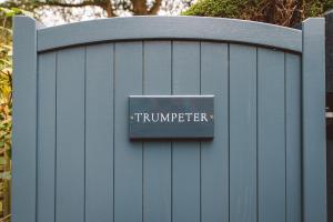 a sign on a blue fence with the word sqor at The Swan Hotel in Bibury