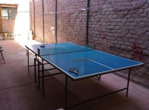 two ping pong tables in a room with a brick wall at Habitación en Ciudad con baño privado en suite y cochera in La Cieneguita