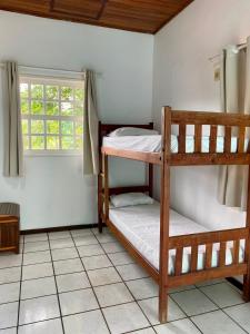 two bunk beds in a room with a window at Pousada das Arvores in Lençóis +90 photos