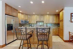 a kitchen with wooden cabinets and stainless steel appliances at Lion Square Lodge North 296 in Vail