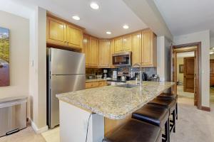 a kitchen with a granite counter top and wooden cabinets at Lion Square Lodge South 550 in Vail