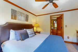 a bedroom with a blue bed with a ceiling fan at Lion Square Lodge South 650 in Vail +38 photos