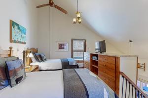 a bedroom with two beds and a dresser with a tv at Lion Square Lodge South 556 in Vail +30 photos