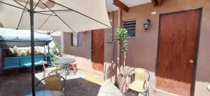 un patio avec une table, des chaises et un parasol dans l'établissement casa saire, à San Pedro de Atacama