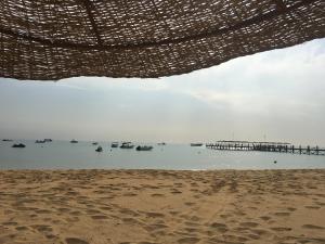 una vista di una spiaggia con barche in acqua di 3-Brs Beachside Modern chalet Seaview & 3min walking l BBQ a Ain Sokhna