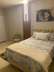 a bedroom with a bed and a painting on the wall at Pousada Le Sorelle apt6 in Rosário do Sul