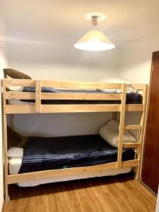 two bunk beds in a room with a light at Appartement au pied des pistes et du telemix in Les Deux Alpes