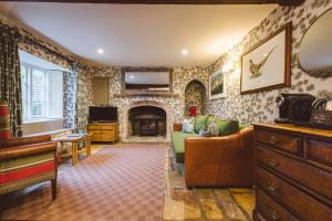 a living room with a couch and a fireplace at The Swan Hotel in Bibury
