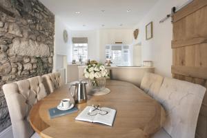 a wooden table in a room with a kitchen at Wharton Cottage, Lake District Retreat in Cartmel