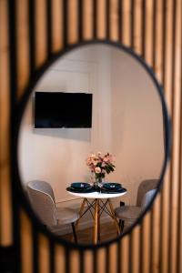 a table with chairs and a vase of flowers at Apartament Wolności in Jelenia Góra +2 photos