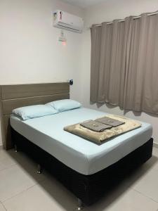 a bed with a blanket on it in a room at Pousada e Casa Praias de Penha in Penha