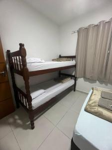 a small room with a bunk bed and a bed gmaxwell gmaxwell gmaxwell gmaxwell gmaxwell gmaxwell at Pousada e Casa Praias de Penha in Penha