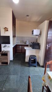 a kitchen with a counter and a table in it at Apto Arejado em Ubatuba Próximo a Praia in Ubatuba