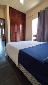 a bedroom with a large bed with a blue blanket at Apto Arejado em Ubatuba Próximo a Praia in Ubatuba +7 photos