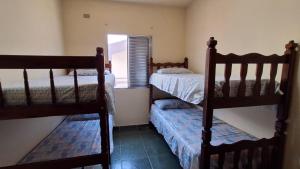 two bunk beds in a room with a window at Apto Arejado em Ubatuba Próximo a Praia in Ubatuba