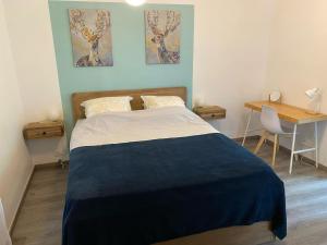sypialnia z łóżkiem z biurkiem i 2 zdjęciami na ścianie w obiekcie Le gîte de La Villénie - en pleine Nature - 5 min centre ville de Sarlat w mieście Sarlat-la-Canéda +37 zdjęć