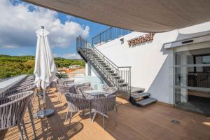 a balcony with tables and chairs and a staircase at Neptuno Aparthotel in Calella