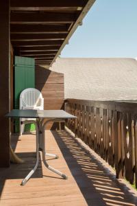 a table and a chair on a wooden deck at Chalet Wurzenbord 1 in Bettmeralp