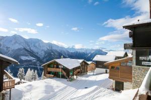 a ski lodge in the snow with mountains in the background at Chalet Wurzenbord 1 in Bettmeralp
