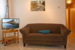 a living room with a brown couch and a tv at Chalet Wurzenbord 1 in Bettmeralp +18 photos