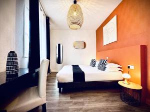 a bedroom with a bed with an orange wall at Hôtel Jules in Le Touquet-Paris-Plage
