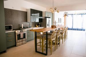 a kitchen with a wooden island with bar stools at N1 Condos in San Juan