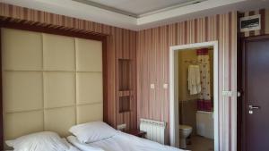 a bedroom with a bed and a bathroom at Bozukova House in Sliven