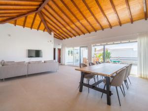 a dining room with a wooden table and chairs at VILLA LOBOS with private pool and BBQ in Caleta De Fuste