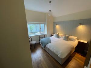 una camera da letto con un letto bianco e una finestra di The Arch House a Enniskerry