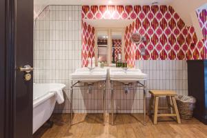 a bathroom with two sinks and a tub and a mirror at The Swan Hotel in Bibury