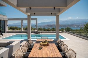 a patio with a table and chairs and a swimming pool at Sunny Vacay Villa in Stérnai